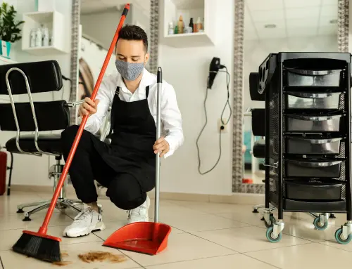 a person wearing a face mask and holding a broom and dustpan