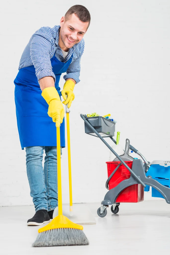 a person in a blue apron and yellow gloves mopping the floor