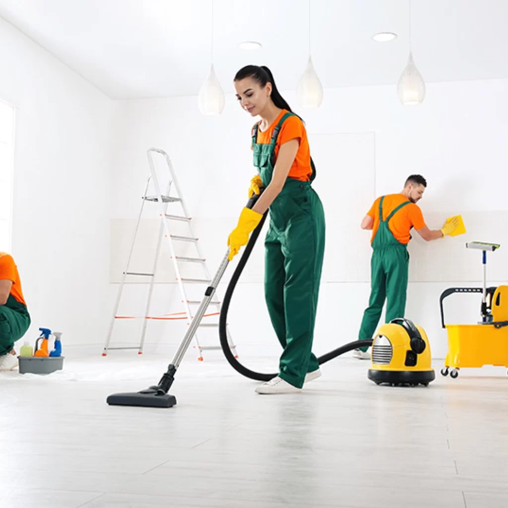 a group of people in overalls cleaning a room