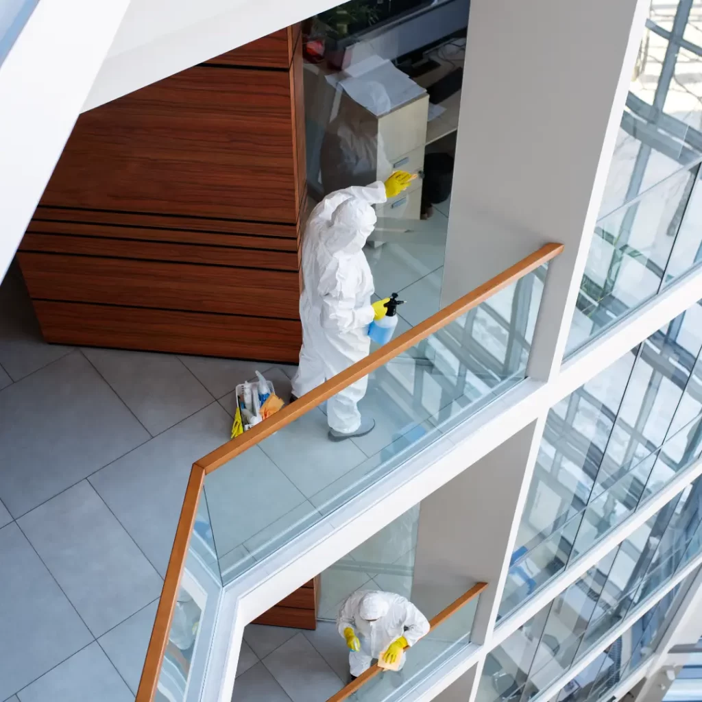 a person in hazmat suit cleaning a building