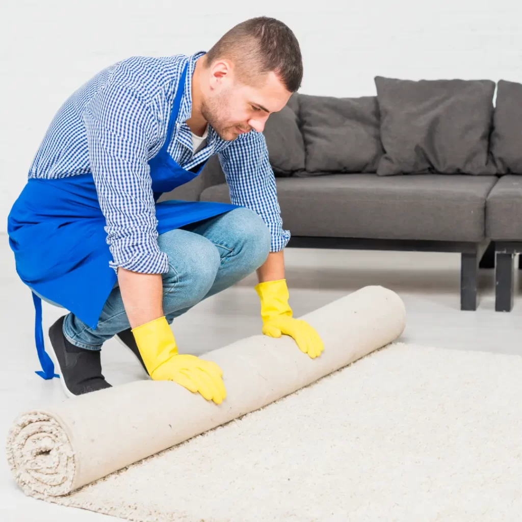 a person in a blue apron rolling a rug