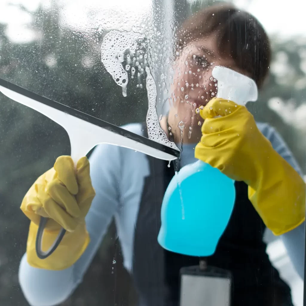 a person cleaning a window with a squeegee